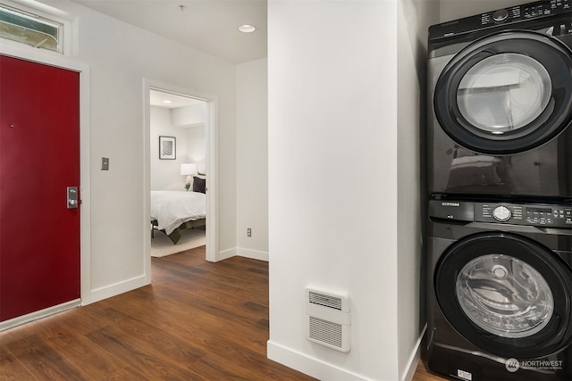 laundry area with dark wood-type flooring and stacked washer and dryer