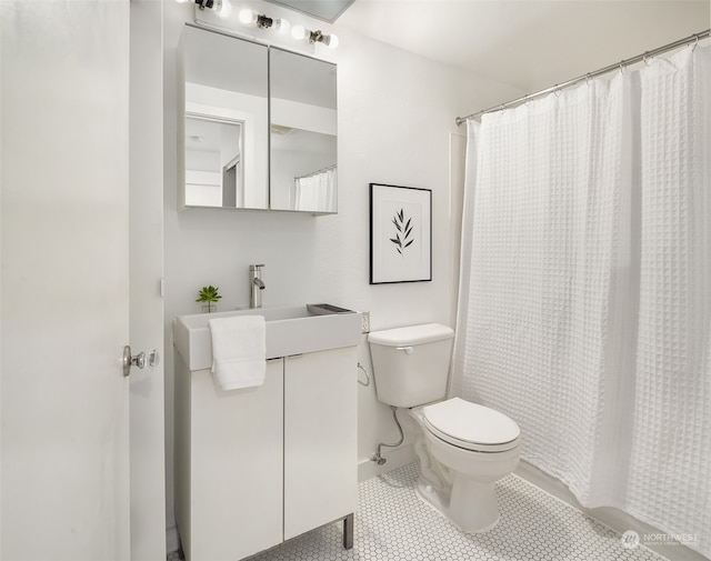 bathroom featuring tile patterned flooring, vanity, walk in shower, and toilet