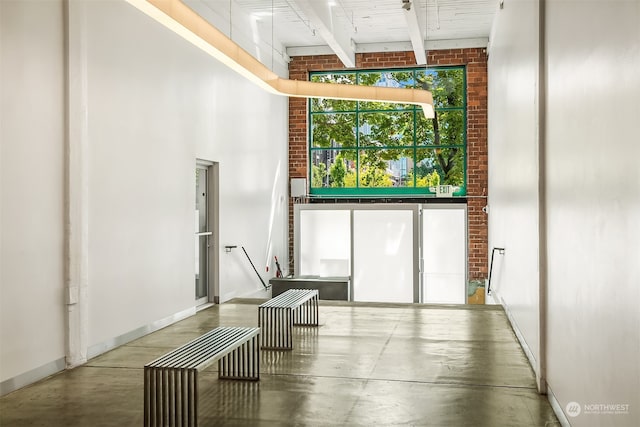 interior space featuring beam ceiling, high vaulted ceiling, concrete floors, and wood ceiling