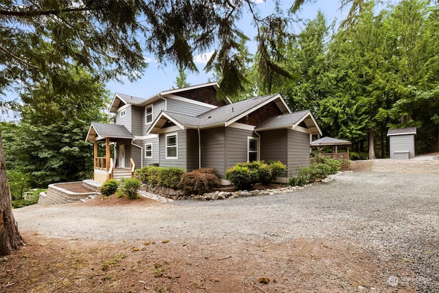 view of front of home with an outbuilding, driveway, and a shed