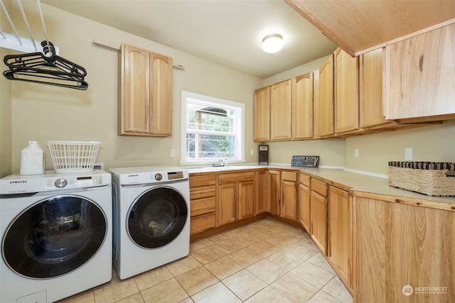 laundry area featuring light tile patterned floors, cabinet space, a sink, and separate washer and dryer