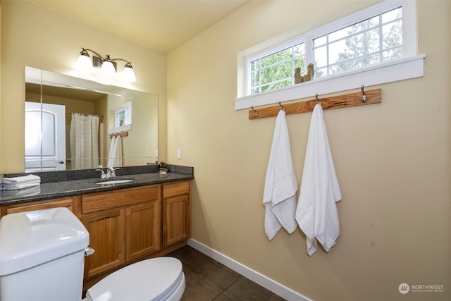 full bath with toilet, vanity, baseboards, and tile patterned floors