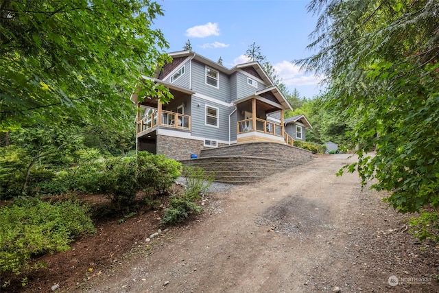 view of front facade with driveway and stone siding