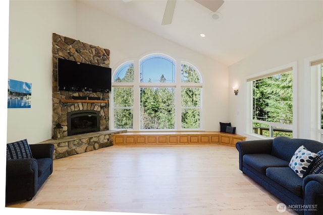 living area featuring ceiling fan, high vaulted ceiling, recessed lighting, a fireplace, and light wood-type flooring