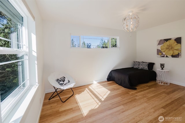 bedroom with a chandelier, baseboards, and wood finished floors