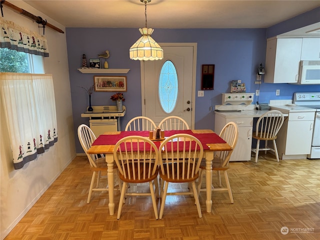 dining space featuring washer / dryer and light parquet floors