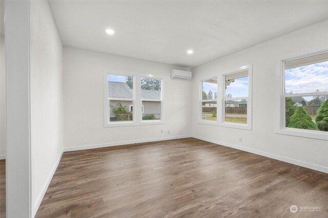 empty room featuring dark hardwood / wood-style floors and a wall mounted air conditioner