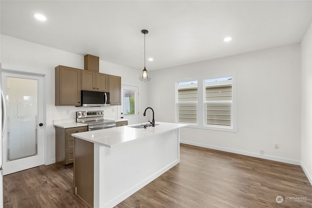 kitchen with sink, hanging light fixtures, a center island with sink, appliances with stainless steel finishes, and dark hardwood / wood-style flooring