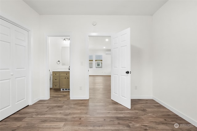 unfurnished bedroom featuring a closet, hardwood / wood-style flooring, and ensuite bathroom