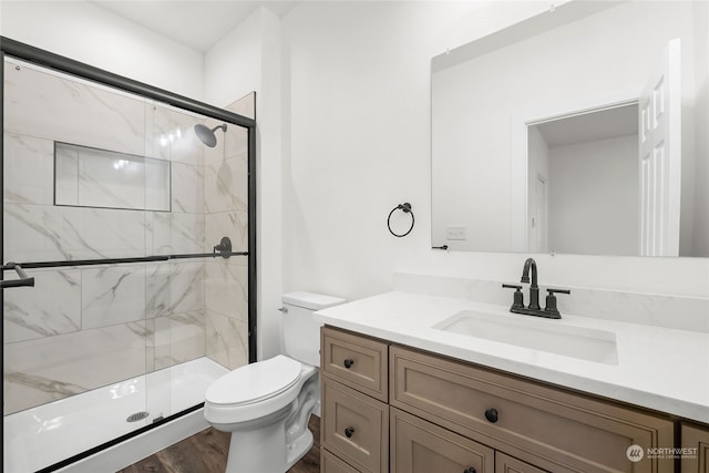 bathroom featuring walk in shower, hardwood / wood-style floors, vanity, and toilet