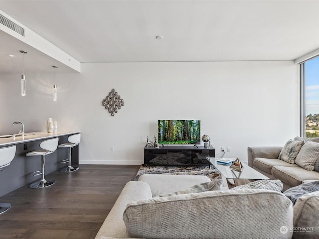 living room featuring dark wood finished floors, baseboards, and visible vents