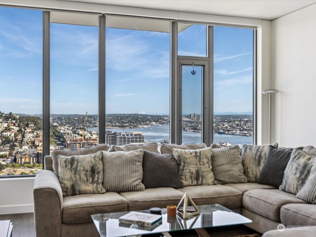 living room with hardwood / wood-style flooring, floor to ceiling windows, and a water view