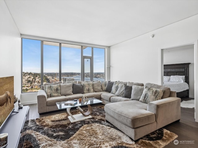 living area with wood finished floors, baseboards, and a water view