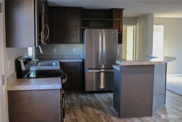 kitchen with dark brown cabinets, sink, appliances with stainless steel finishes, and hardwood / wood-style flooring