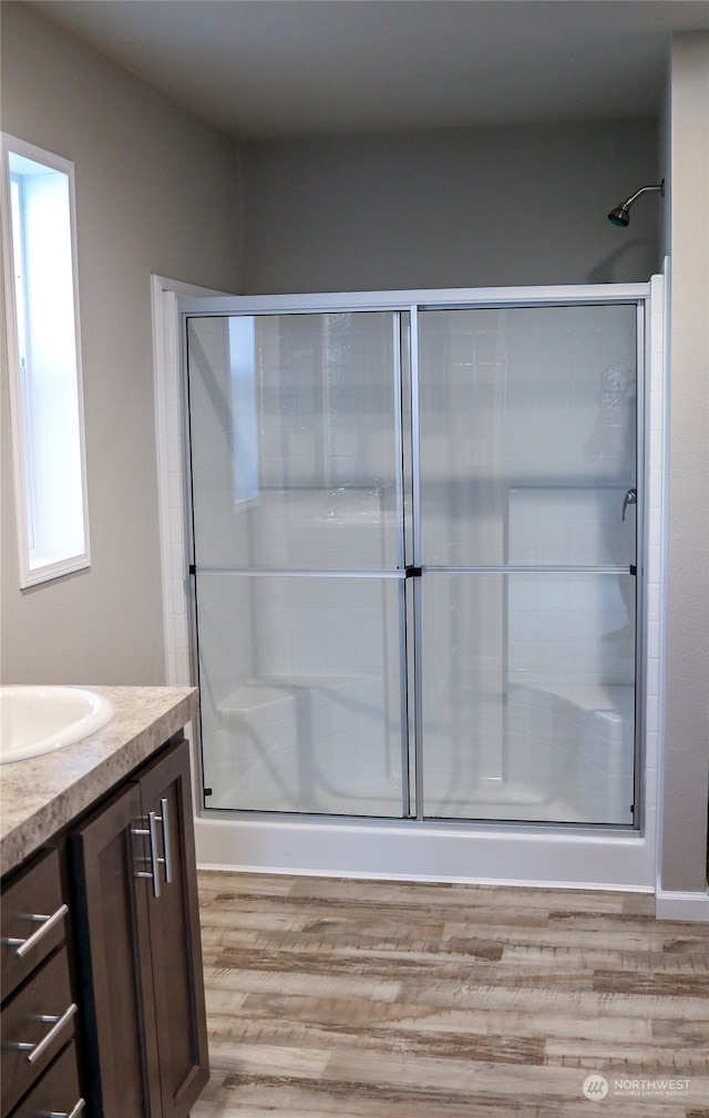 bathroom with vanity, hardwood / wood-style floors, and an enclosed shower