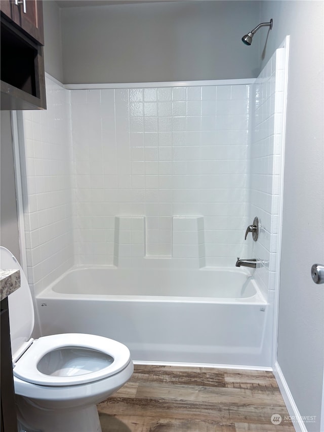 bathroom featuring hardwood / wood-style floors, shower / bath combination, and toilet