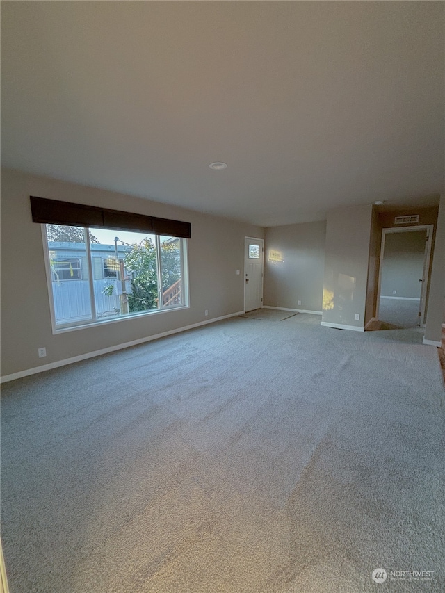 unfurnished living room featuring light colored carpet