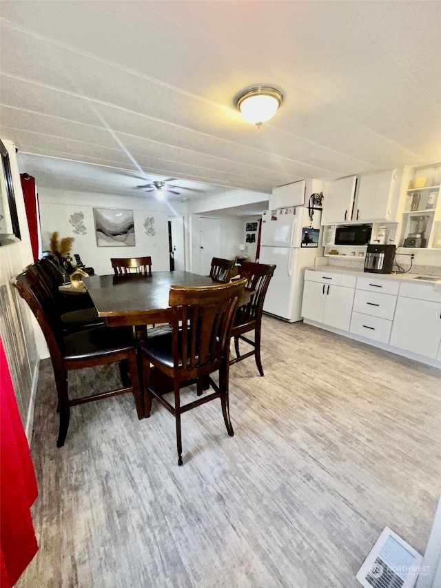 dining space with ceiling fan and light hardwood / wood-style floors