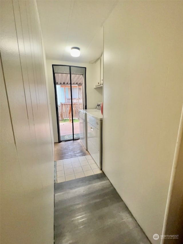 hallway with independent washer and dryer and light tile patterned flooring