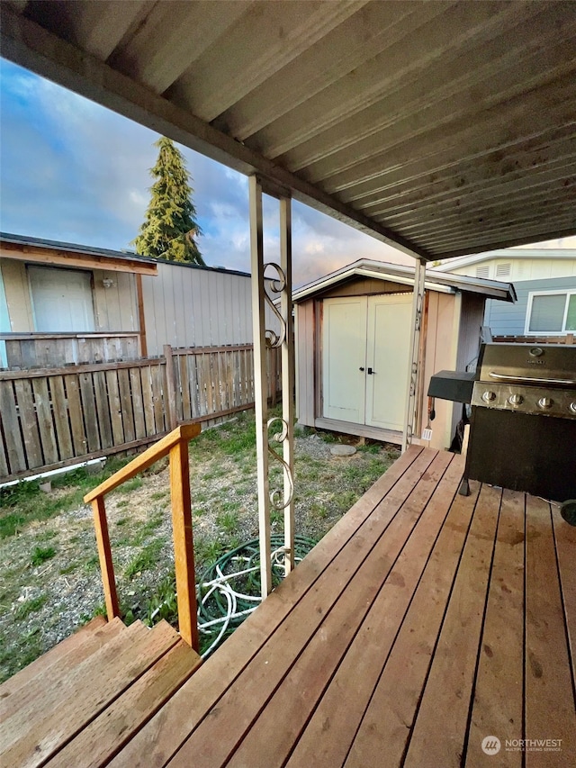 wooden deck with a storage unit and grilling area