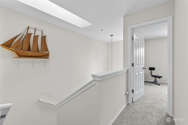 hall with carpet flooring and a skylight