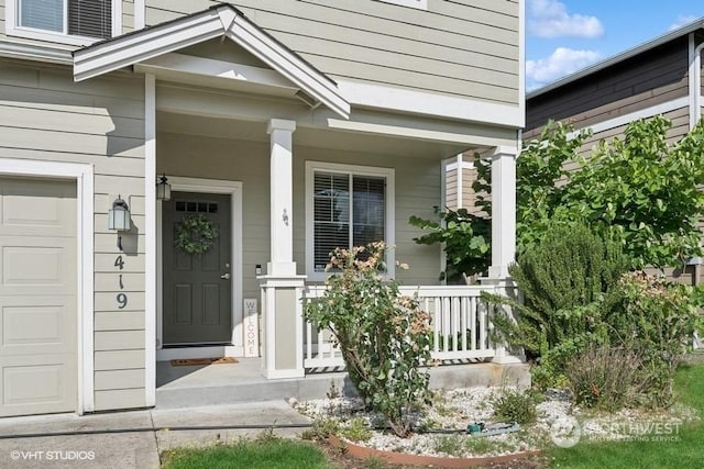 entrance to property with an attached garage and a porch