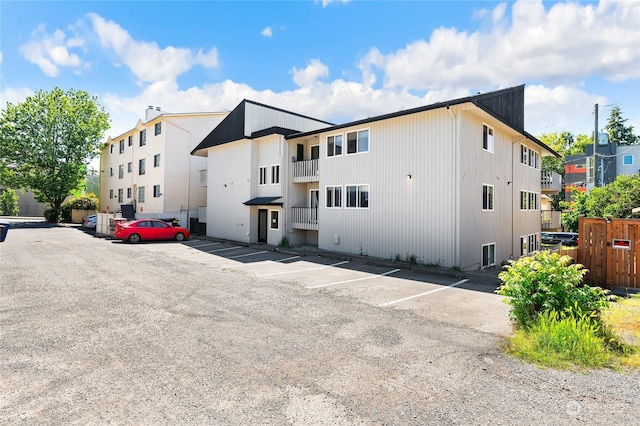 view of building exterior with uncovered parking and a residential view