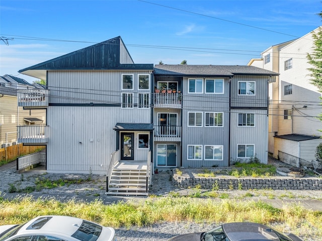 view of front of property featuring a balcony and central AC unit