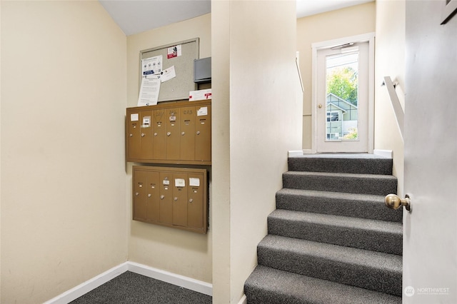 stairs featuring mail area, baseboards, and carpet floors