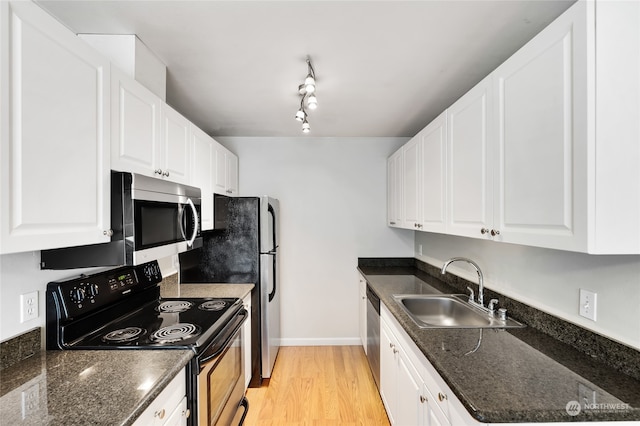 kitchen with stainless steel appliances, rail lighting, sink, light wood-type flooring, and white cabinets