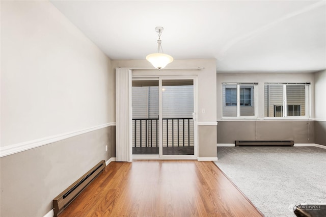 interior space with baseboards, baseboard heating, and wood finished floors