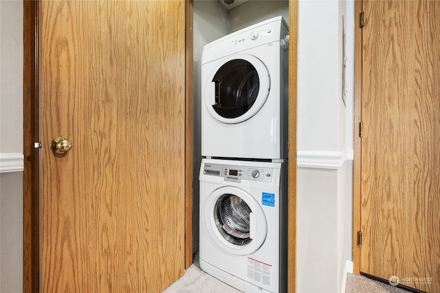 clothes washing area featuring stacked washer / drying machine