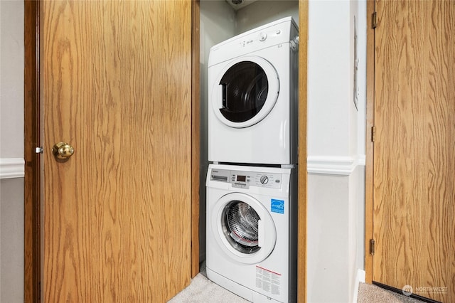 clothes washing area featuring stacked washing maching and dryer