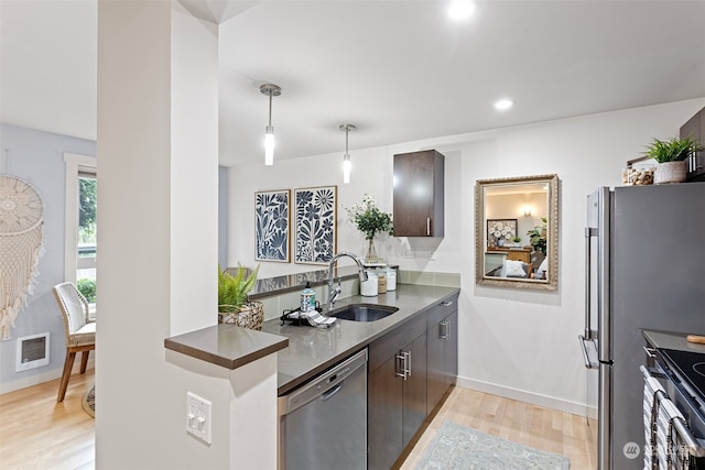 kitchen featuring sink, appliances with stainless steel finishes, dark brown cabinetry, and light hardwood / wood-style floors