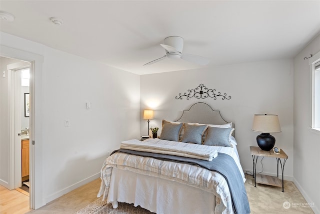 bedroom featuring ceiling fan, ensuite bathroom, and light carpet