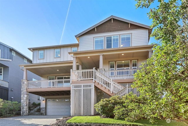 view of front of property with a porch, a garage, stairs, driveway, and board and batten siding