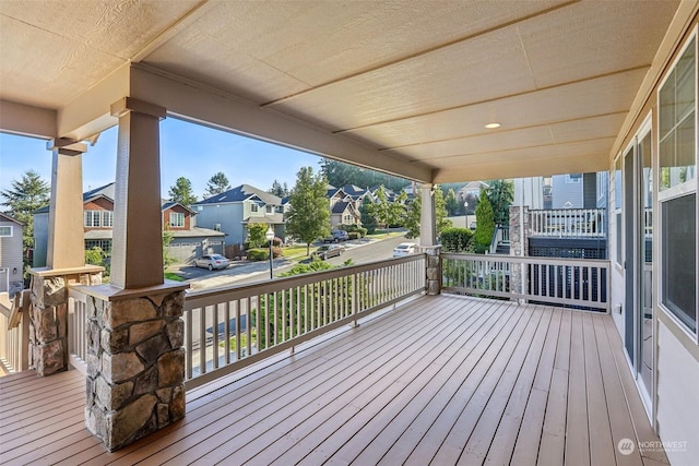 wooden deck featuring a residential view and a porch