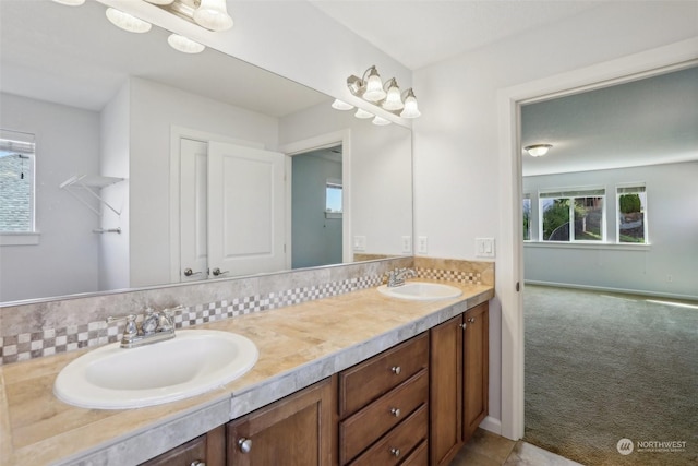 bathroom with a sink, baseboards, and double vanity