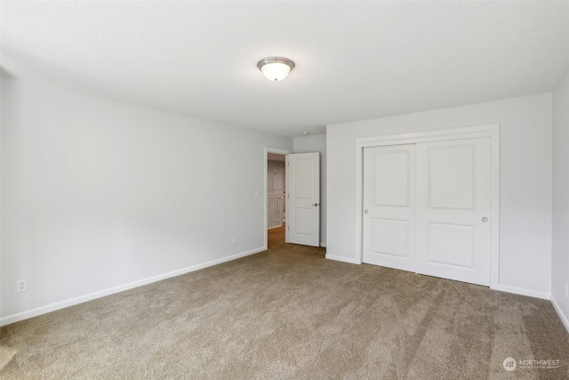 unfurnished bedroom featuring a closet, carpet flooring, and baseboards