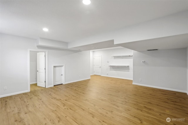 unfurnished living room with light wood finished floors, recessed lighting, visible vents, and baseboards