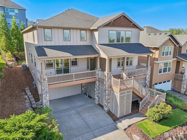 view of front of home with a garage, a shingled roof, stairs, driveway, and board and batten siding