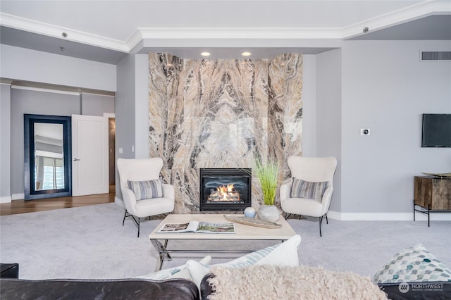 living room with baseboards, visible vents, crown molding, carpet floors, and a fireplace