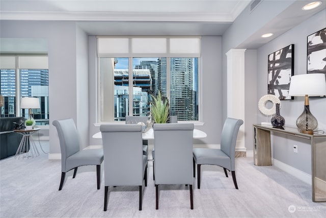 carpeted dining space with ornamental molding