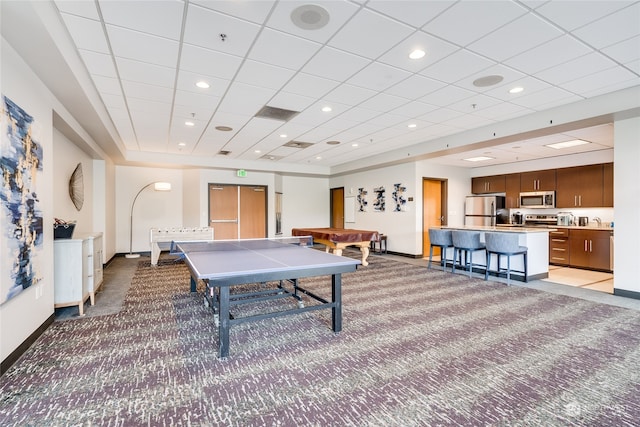 rec room with pool table, a drop ceiling, and light carpet