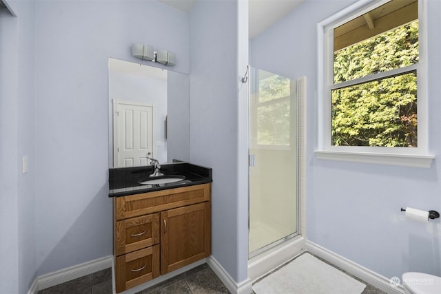 bathroom featuring a shower with door, vanity, toilet, and tile patterned floors