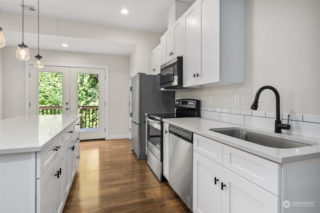 kitchen featuring decorative light fixtures, dark hardwood / wood-style flooring, appliances with stainless steel finishes, sink, and white cabinets