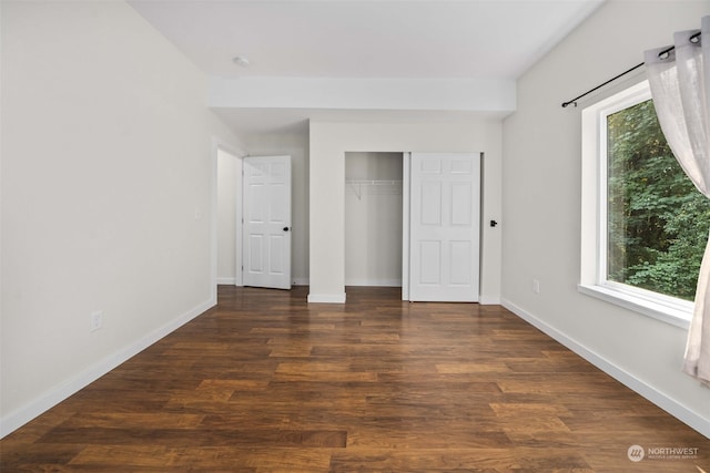 unfurnished bedroom with dark wood-type flooring and a closet