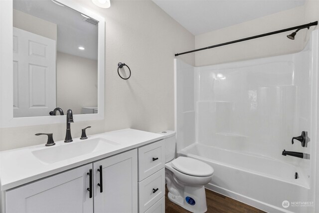 full bathroom featuring vanity, toilet, washtub / shower combination, and hardwood / wood-style flooring