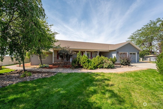 single story home with an attached garage, covered porch, a front lawn, and concrete driveway