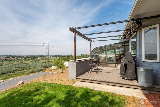 wooden terrace featuring a yard and a pergola